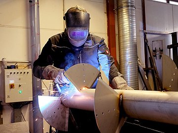 Ein Schweißer bei der Arbeit bei IBO Stalltechnik