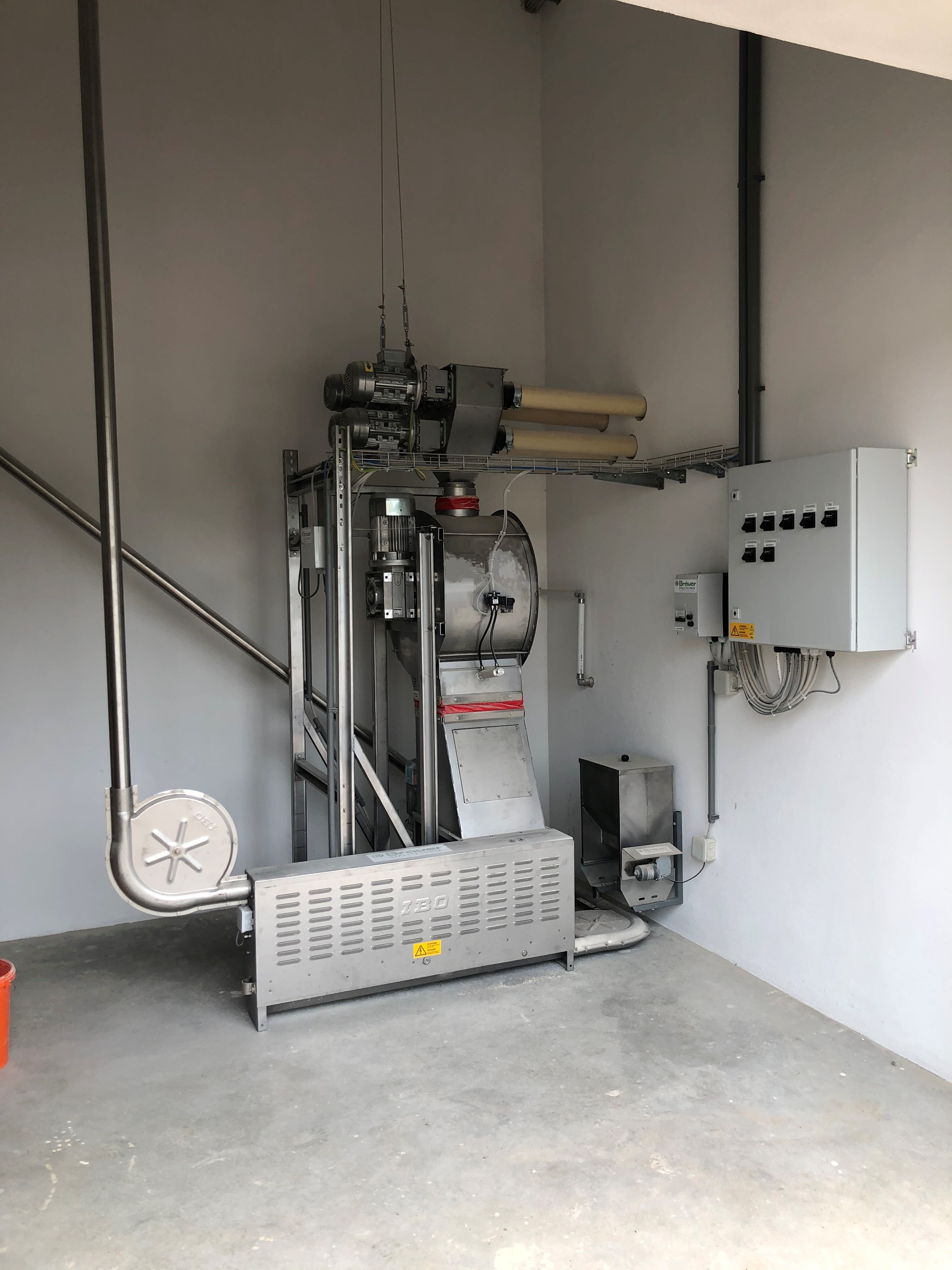 Ein Chargenmischer von IBO Stalltechnik. Dieses Gerät dient zum präzisen Mischen von verschiedenen Futterkomponenten zu einer homogenen Charge für die Tierfütterung. Das Bild zeigt den Mischer, der typischerweise in einer Futterküche oder Mischanlage installiert ist.